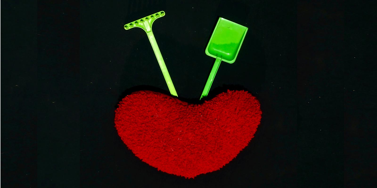 Un râteau et une pelle autour d'un coeur