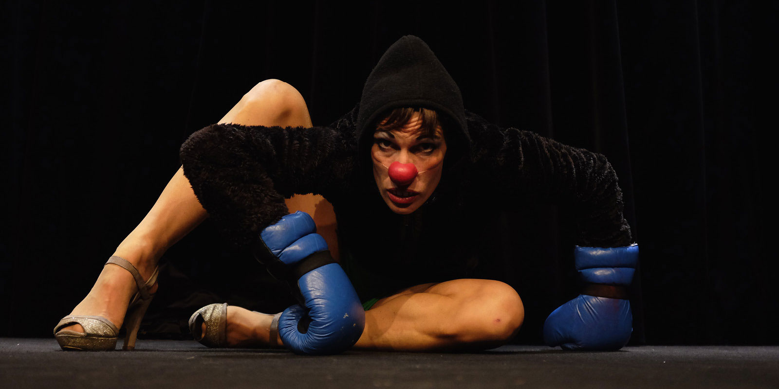 Photo d'une femme clown avec des gants de boxe bleu.