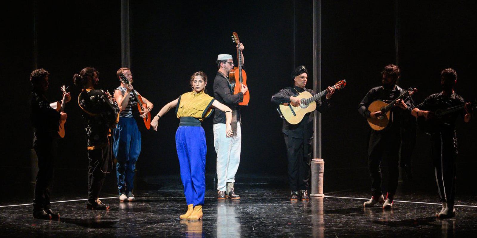 Photo issue du spectacle "Bate Fado" avec 7 guitaristes et une danseuse flamenco.